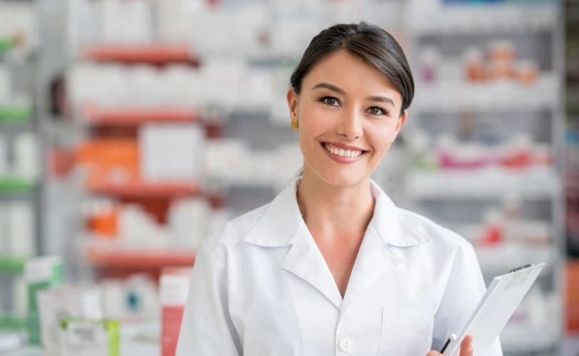 Smiling pharmacist holding a clipboard in a pharmacy